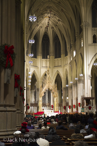 Inside St. Patrick's Cathedral. I photographed this NYC landmark shortly before Christmas, with the 7D and 17-55mm lens-handheld, with image stabilization engaged, all at ISO 400. Vertical: available light, f/2.8, 1/15 sec, at 35mm (= 56mm in 35mm equivalent). Verticals with lens tilted upward: here I shot by available light and then flash (apparent by all the brightly lit backs of heads), with the lens at 17mm (= 27mm) and an available-light exposure at 1/10 sec (1/60 with flash). Horizontals: even bounce flash (evident with the bright vaulting arch framing the sculpture) was not an ideal solution, and the existing lighting proved to be a better choice. The flash used was a Canon 580EX.  ©Jack Neubart. All rights reserved.