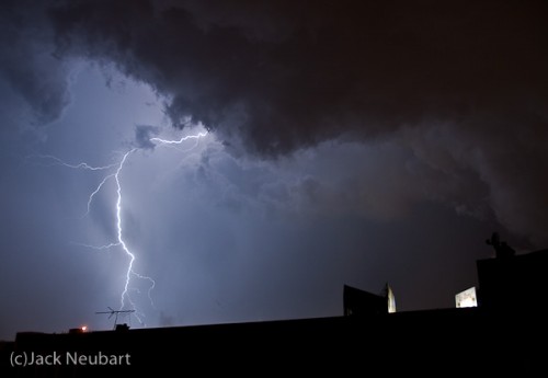 Lightning. Seeing flashes of lightning outside as I was working at the computer, I grabbed my Nikon D300 and mounted the 18-200mm VR lens onto it. Then I attached the camera to a table-pod that I'd bought at Spiratone ages ago and stuck it out the window, leaning the pod on the window sill while holding the camera, finger poised on the shutter button. But considering that this arrangement was still not the steadiest, I invoked Vibration Reduction on the lens, after setting the shutter speed to 1/4 second and focal length to 18mm. (I cropped out a piece of wall and billboard that intruded on the shot all the way to the left.) Copyright  ©2009 Jack Neubart. All rights reserved.