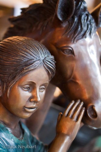 Girl & Horse. I had come upon some bronze-like, life-size plaster sculptures on the street when the light was waning. Knowing flash would throw back glaring reflections, I opted to shoot by available light. I took advantage of that wide aperture to shoot handheld, using exposures as slow as 1/50th second (ISO 800). Copyright  ©2009 Jack Neubart. All rights reserved.