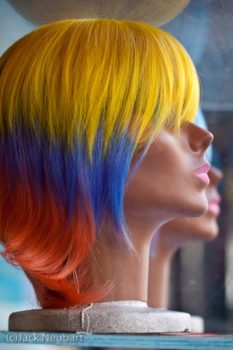  Head Shot. The wildly colored wig caught my eye when I came upon this mannequin head in a display case on the street. With enough light to expose at ISO 100, I shot wide open to blur out the surroundings and the second head, which gave me a 1/160 sec shutter speed, easily enough to prevent camera shake. Copyright  ©2009 Jack Neubart. All rights reserved.